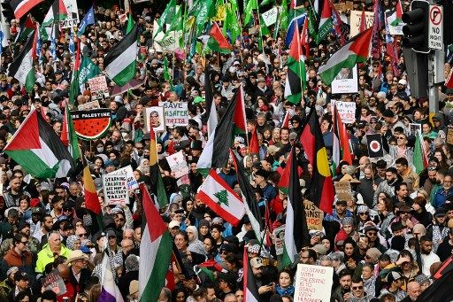 Protesters in support of Palestinians in Gaza hold flags and placards as they march toward the Harbour Bridge during a demonstration against the actions of Israel, in Sydney on August 3, 2025. (Photo by Saeed KHAN / AFP)