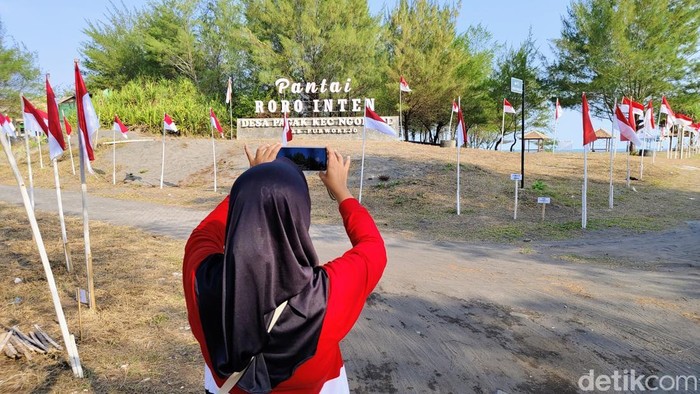Pengunjung menikmati pemandangan 2.025 Bendera di Pantai Roro Inten, Desa Pagak, Kecamatan, Ngombol, Purworejo, Minggu (3/8/2025).