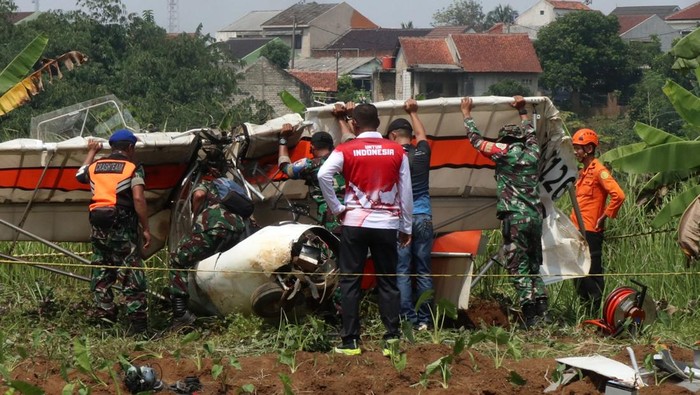 Petugas Basarnas berbareng prajurit TNI AU berupaya mengevakuasi buntang pesawat latih sipil Microlight Fixedwing Quicksilver GT500 dengan register PK-S126 nan jatuh di perkebunan warga, TPU Astana, Ciampea, Kabupaten Bogor, Jawa Barat, Minggu (3/8/2025). Pesawat latih sipil milik Federasi Aero Sport Indonesia (FASI) nan mengalami lenyap kontak pada pukul 09.19 WIB ditemukan jatuh di sekitar TPU tersebut dan menyebabkan satu orang meninggal bumi dan satu orang mengalami luka berat dan dibawa ke RSAU dr. M. Hassan Toto, Bogor. ANTARA FOTO/Fadli/Arf/rwa.