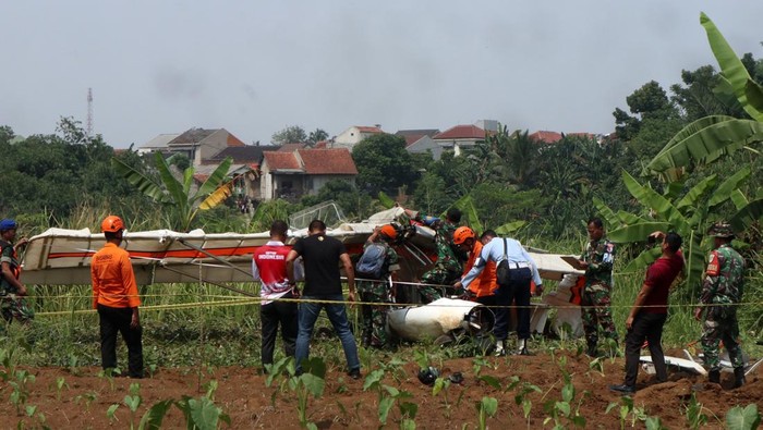 Evakuasi bangkai pesawat latih di Bogor Petugas Basarnas bersama prajurit TNI AU berusaha mengevakuasi bangkai pesawat latih sipil Microlight Fixedwing Quicksilver GT500 dengan register PK-S126 yang jatuh di perkebunan warga, TPU Astana, Ciampea, Kabupaten Bogor, Jawa Barat, Minggu (3/8/2025). Pesawat latih sipil milik Federasi Aero Sport Indonesia (FASI) yang mengalami hilang kontak pada pukul 09.19 WIB ditemukan jatuh di sekitar TPU tersebut dan menyebabkan satu orang meninggal dunia dan satu orang mengalami luka berat dan dibawa ke RSAU dr. M. Hassan Toto, Bogor. ANTARA FOTO/Fadli/Arf/rwa.