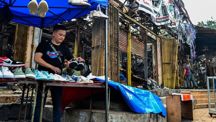 Pedagang menata dagangan di Pasar Taman Puring, Jakarta, Minggu (3/8/2025). Pedagang mengaku, tetap berjualan di sekitar lokasi sambil menunggu kepastian perbaikan pascakebakaran di Pasar Taman Puring yang terjadi pada Senin (28/7/2025) malam lalu. ANTARA FOTO/Ertadha Sulthan/rwa.