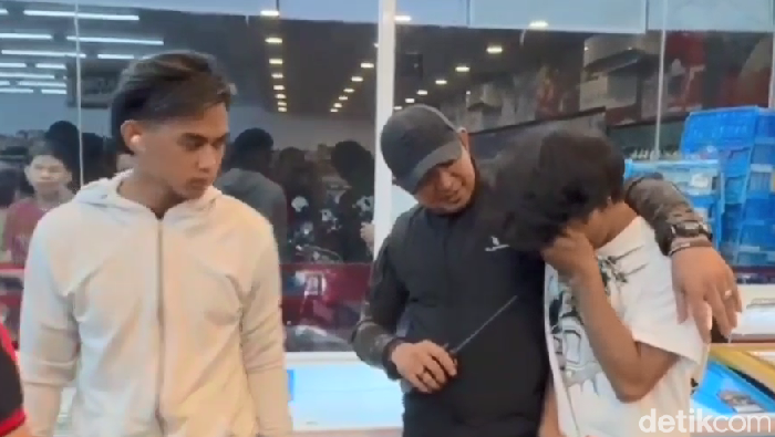 Pemuda (kaos putih) di Makassar menangis ditangkap polisi usai kepergok mencuri di minimarket.
