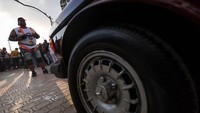 Pegulat Mesir Ashraf Mahrous, yang dikenal sebagai Ashraf Kabonga, menarik 20 mobil sejauh 10 meter pada hari Jumat (1/8) dalam upaya mencetak Rekor Dunia Guinness. Ashraf Kabonga bersiap di garis start, diapit puluhan mobil dan ratusan penonton yang memenuhi jalan kota 10 Ramadan, Sharqia, Mesir. Foto: REUTERS/Amr Abdallah Dalsh