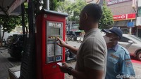 Warga dibantu petugas parkir melakukan pembayaran pada mesin terminal parkir elektronik (TPE) di Jalan Sabang, Jakarta Pusat, Senin (04/8/2025).