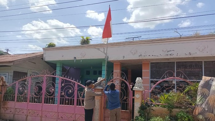 Bhabinkamtibmas Dumai Kota turun ke permukiman warga memasangkan bendera Merah Putih menjelang HUT ke-80 RI.