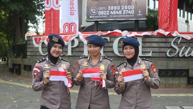 Brimob Polda Metro Jaya turun membagikan ribuan bendera Merah Putih ke pengendara menyambut HUT ke-80 RI, Senin (4/8/2025).