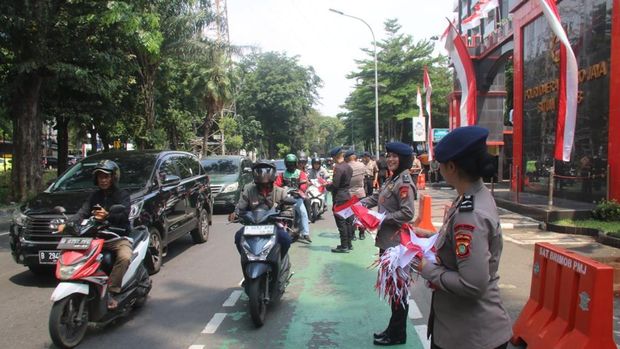 Brimob Polda Metro Jaya turun membagikan ribuan bendera Merah Putih ke pengendara menyambut HUT ke-80 RI, Senin (4/8/2025).