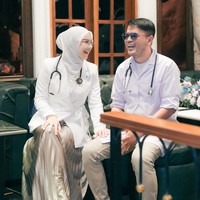 Penampilan Irish senada dengan sang suami, Haldy Sabri yang juga memilih busana bernuansa putih dan coklat. Haldy juga tampak mengalungkan stetoskop di lehernya. Foto: Instagram/@_irishbella_