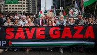 Massa mengibarkan bendera Palestina dan poster protes. Mereka menyerukan gencatan senjata dan bantuan kemanusiaan segera ke Gaza. (Izhar Khan/Getty Images)  