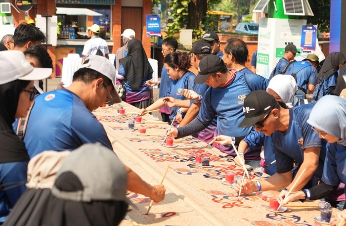 Peserta melukis di atas sak semen dalam event perayaan ulang tahun ke-50 PT Indocement Tunggal Prakarsa Tbk., digelar Sabtu (2/8/2025) di Taman Mini Indonesia Indah (TMII).