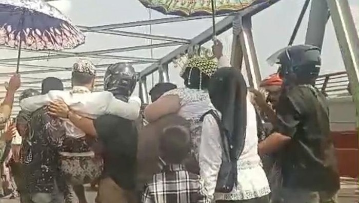 Pasangan pengantin Ade dan Putri digotong saat seberangi jembatan Pemali, Brebes.