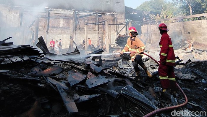Petugas pemadam kebakaran saat memadamkan api di gudang mebel Pasuruan