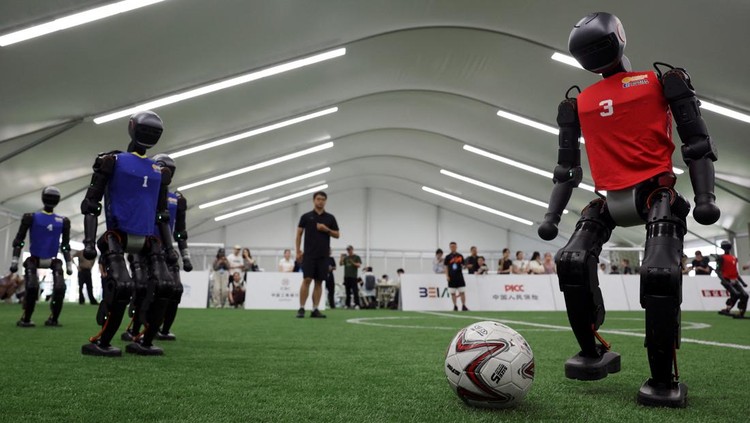 T1 humanoid robots developed by Booster Robotics in action on a football pitch, during a practice in preparation for soccer competitions at the inaugural World Humanoid Robot Games, at the National Speed Skating Oval in Beijing, China August 1, 2025. REUTERS/Florence Lo