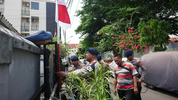 Satuan Brimob Polda Metro membagikan bendera Merah Putih di rumah penduduk jelang peringatan HUT ke-80 RI. (dok istimewa)