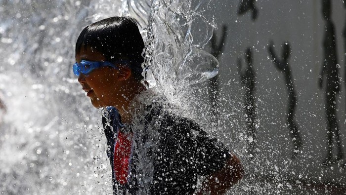 Tokyo Lagi Panas Banget, Anak-anak Mandi di Air Mancur Tokyo diterjang gelombang panas ekstrem disertai peringatan heatstroke. Anak-anak memanfaatkan air mancur taman sebagai tempat bermain dan menyegarkan diri.