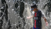 Air mancur menjadi tempat pelarian sejenak dari panas yang menyengat. REUTERS/Issei Kato