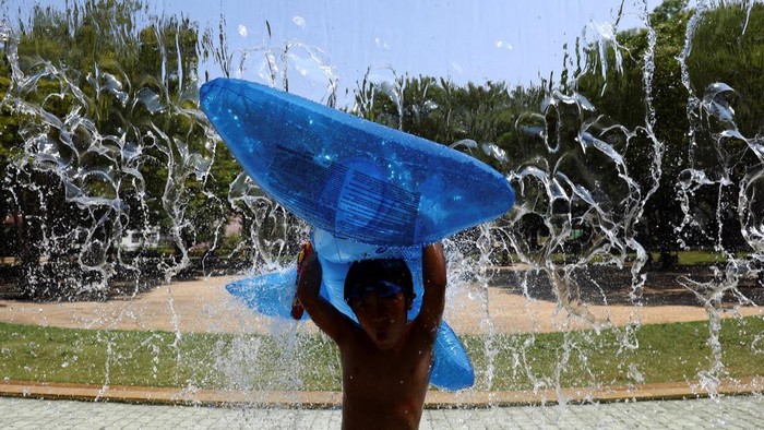 Tokyo Lagi Panas Banget, Anak-anak Mandi di Air Mancur Tokyo diterjang gelombang panas ekstrem disertai peringatan heatstroke. Anak-anak memanfaatkan air mancur taman sebagai tempat bermain dan menyegarkan diri.