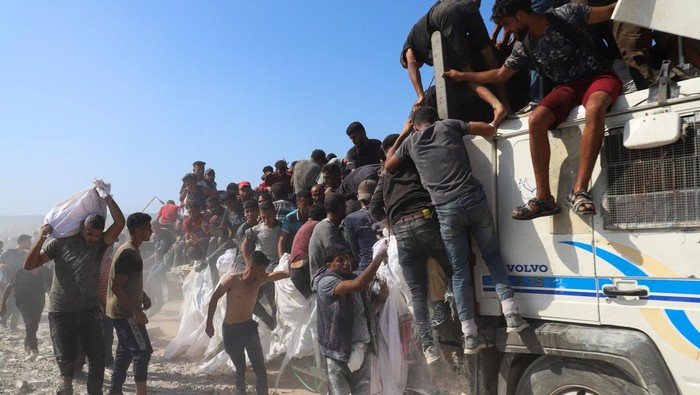 Warga Gaza Serbu Truk Pembawa Bantuan Palestinians ride on the back of a truck, after aid supplies that entered Gaza through Israel were distributed, in Beit Lahia in the northern Gaza Strip, August 3, 2025. REUTERS/Ebrahim Hajjaj