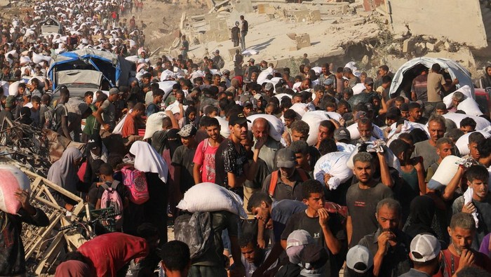 Warga Gaza Serbu Truk Pembawa Bantuan Palestinians ride on the back of a truck, after aid supplies that entered Gaza through Israel were distributed, in Beit Lahia in the northern Gaza Strip, August 3, 2025. REUTERS/Ebrahim Hajjaj