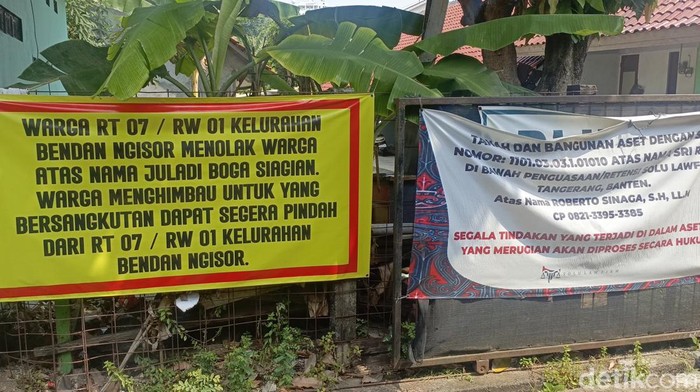 Warga memasang spanduk ke pagar arah masuk tempat tinggal keluarga Juladi Siagian (54) di Lamongan, Bendan Ngisor, Kecamatan Gajahmungkur, Kota Semarang, Senin (4/8/2025).