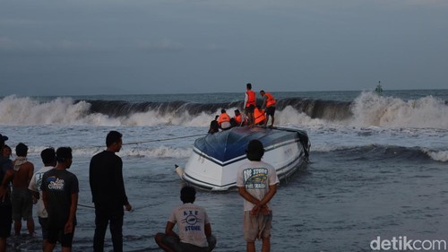 Badan kapal cepat Dolphin II yang masih terbalik di bibir Pantai Matahari Terbit, Selasa (5/8/2025). (Aryo Mahendro)