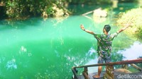 Seorang pengunjung berpose di Danau Nyadeng. Danau ini menawarkan segudang aktivitas untuk jiwa petualang. Berenang di air sejuk dan jernih jadi pilihan utama, dengan pelampung tersedia untuk yang tidak mahir berenang.