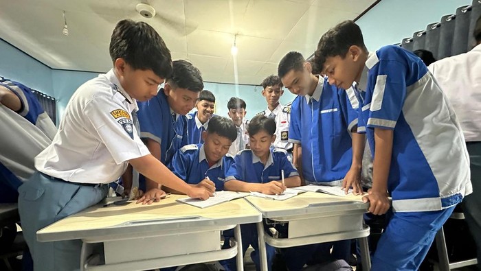 Enggar bersama tampak akrab bersama teman-teman sekelas yang telah patungan membelikannya sepatu baru.