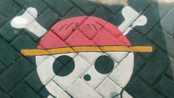 Gambar Jolly Roger atau bendera di anime One Piece yang diterapkan di paving sejumlah kampung di Surabaya jelang HUT ke-80 RI.