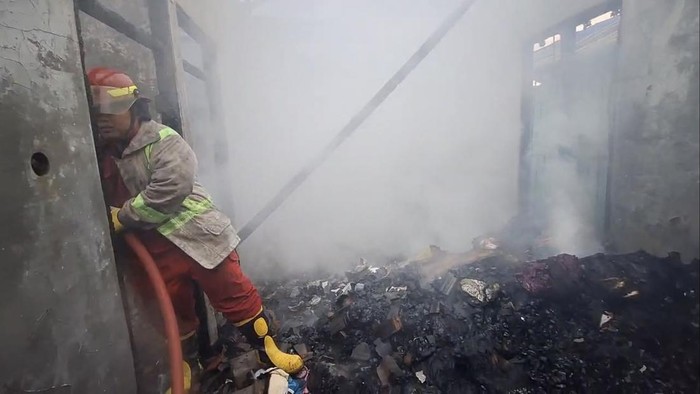 Petugas dari Damkar tengah memadamkan kebakaran rumah di Desa Pomahan, Sulang, Rembang, Selasa (5/8/2025).