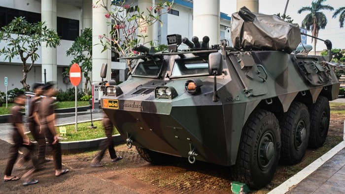 Pegawai melintas di dekat kendaraan taktis Panser Anoa 6x6 milik TNI yang terparkir di Kejaksaan Agung, Jakarta, Selasa (5/8/2025). Kepala Pusat Penerangan Hukum Kejaksaan Agung, Anang Supriatna menjelaskan bahwa kehadiran dua kendaraan militer tersebut berkaitan dengan pengamanan rutin sekretariat Satuan Tugas (Satgas) Penertiban Kawasan Hutan (PKH) yang sesuai dengan Peraturan Presiden Nomor 66 Tahun 2025 tentang Perlindungan Negara Terhadap Jaksa Dalam Melaksanakan Tugas dan Fungsi Kejaksaan Republik Indonesia. ANTARA FOTO/Sulthony Hasanuddin/bar
