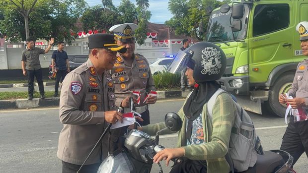 Polres Kuansing turun membagikan bendera Merah Putih menjelang Hari Kemerdekaan RI ke-80, Selasa (4/8/2025).