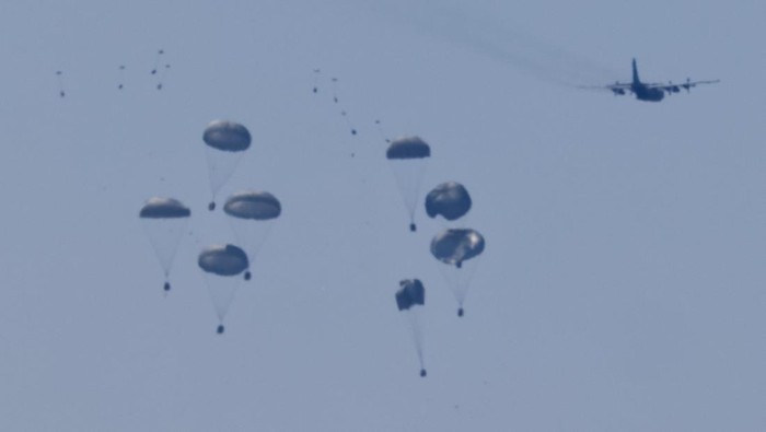 An aircraft drops humanitarian aid packages over the Gaza Strip, as seen from Israel, August 4, 2025. REUTERS/Amir Cohen