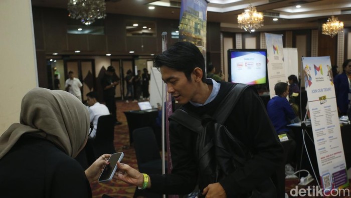 Sejumlah pelamar kerja terlihat mengamati deretan lowongan kerja yang dipasang di arena JobCity Job Fair 2025 di SMESCO, Jakarta, Selasa (5/8/2025). Antusiasme tinggi tampak dari peserta yang hadir sejak pagi.