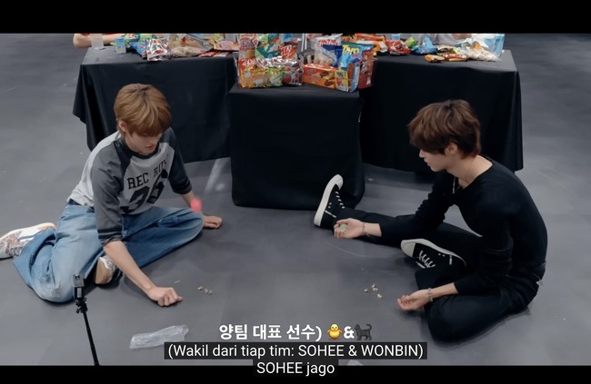 Semakin melokal, dua personel grup KPop RIIZE, Sohee dan Wonbin beradu main bekel untuk memperebutkan camilan yang akan mereka gunakan untuk games menghias rumah-rumahan. Foto: dok. YouTube RIIZE
