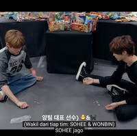 Semakin melokal, dua personel grup KPop RIIZE, Sohee dan Wonbin beradu main bekel untuk memperebutkan camilan yang akan mereka gunakan untuk games menghias rumah-rumahan. Foto: dok. YouTube RIIZE