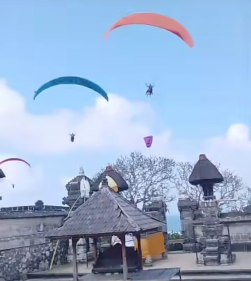 Tangkapan layar video viral paralayang diduga melintas di atas pura diduga Pura Gunung Payung, Kuta Selatan, Badung. (Istimewa)