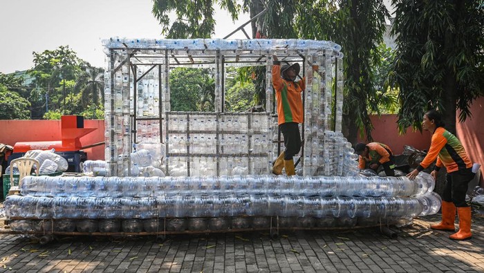 Petugas Unit Penanganan Sampah (UPS) Badan Air Kecamatan Grogol Petamburan membuat perahu berbentuk kereta trem berbahan sampah plastik di Jakarta Barat, Rabu (6/8/2025). UPS Badan Air Kecamatan Kebon Jeruk dan Grogol Petamburan Jakarta Barat memanfaatkan ribuan sampah botol serta galon plastik dari aliran kali untuk dijadikan perahu yang akan digunakan sebagai armada pengangkut sampah di kali wilayah itu. ANTARA FOTO/Sulthony Hasanuddin