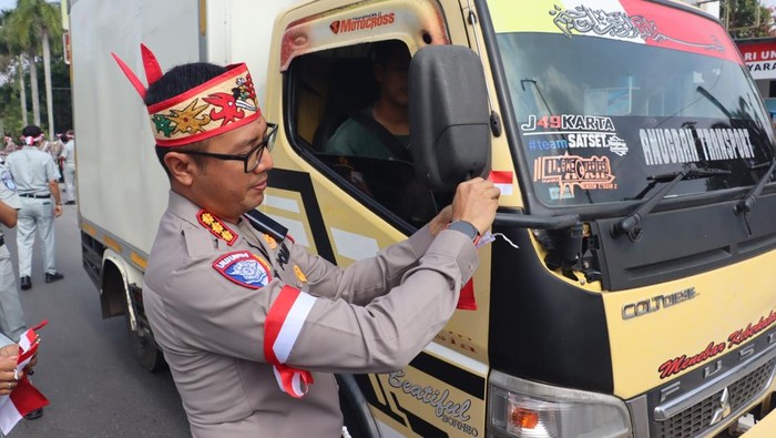 Ditlantas Polda Kalteng melakukan aksi pembagian 1.000 bendera merah putih kepada masyarakat yang sedang melintas di Kota Palangka Raya pada Rabu (6/8/2025).
