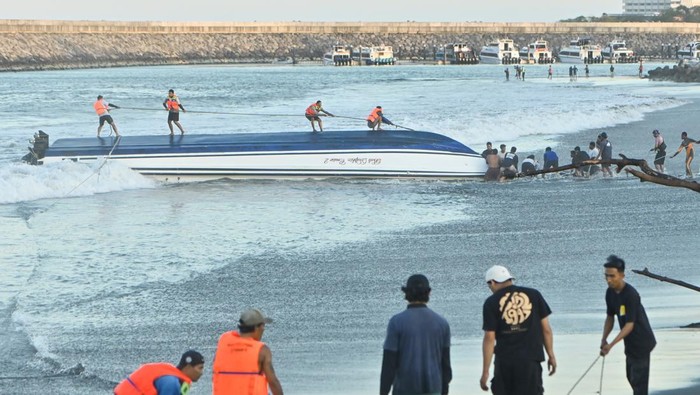 Kapal Wisata Tenggelam di Sanur Bali, 2 Turis Tewas-1 ABK Hilang Petugas bersama warga berusaha menarik kapal cepat Bali Dolphin Cruise 2 ke tepi pantai di kawasan Sanur, Denpasar, Bali, Selasa (5/8/2025). Kapal wisata yang mengangkut 75 penumpang dan lima awak kapal dari Pelabuhan Nusa Penida itu tenggelam dan kandas di alur masuk Pelabuhan Sanur yang mengakibatkan dua orang penumpang warga negara China meninggal dunia serta satu orang awak kapal masih dalam proses pencarian. ANTARA FOTO/Fikri Yusuf/YU