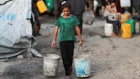 Anak-anak tampak membawa wadah air di tengah suhu tinggi dan antrean panjang di Gaza. REUTERS/Mahmoud Issa