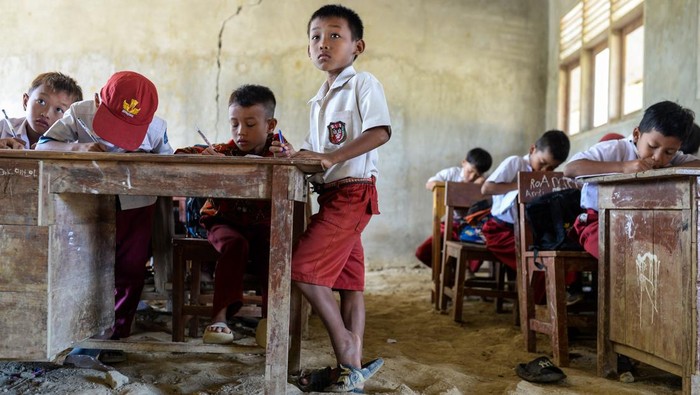 Sejumlah siswa kelas lima menulis saat mengikuti kegiatan belajar mengajar di SD Negeri 1 Curug, Kecamatan Cibaliung, Pandeglang, Banten, Rabu (6/8/2025). Sebanyak dua ruang kelas sekolah tersebut kondisinya beralas tanah sejak tahun 2017 akibat proyek renovasi kelas yang mangkrak karena sulitnya membawa material bangunan menuju sekolah yang berada di pelosok Pandeglang itu. ANTARA FOTO/Muhammad Bagus Khoirunas/foc.