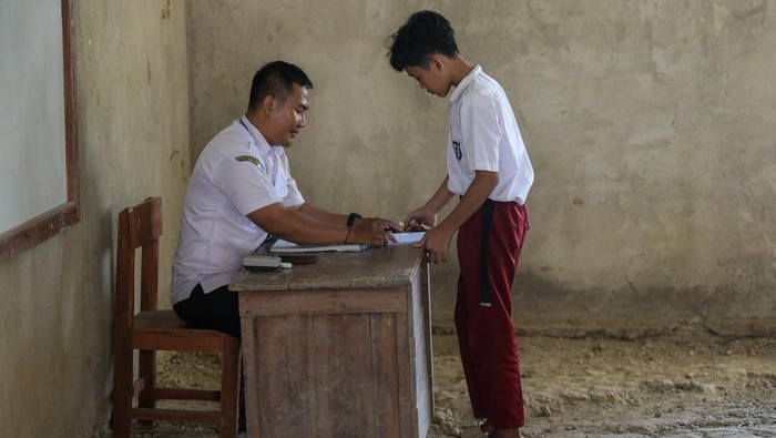 Mangkrak Bertahun-tahun, Renovasi Kelas SDN 1 Curug Tak Kunjung Rampung Sejumlah siswa kelas lima menulis saat mengikuti kegiatan belajar mengajar di SD Negeri 1 Curug, Kecamatan Cibaliung, Pandeglang, Banten, Rabu (6/8/2025). Sebanyak dua ruang kelas sekolah tersebut kondisinya beralas tanah sejak tahun 2017 akibat proyek renovasi kelas yang mangkrak karena sulitnya membawa material bangunan menuju sekolah yang berada di pelosok Pandeglang itu. ANTARA FOTO/Muhammad Bagus Khoirunas/foc.