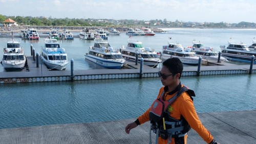 Wisatawan mancanegara bersantai di depan pintu masuk terminal saat penundaan penyeberangan ke Pulau Nusa Penida di Pelabuhan Sanur, Denpasar, Bali, Rabu (6/8/2025). Kepala Kantor Kesyahbandaran dan Otoritas Pelabuhan (KSOP) Kelas II Benoa Aprianus Hangki mengatakan aktivitas penyeberangan di pelabuhan tersebut untuk sementara ditunda hingga waktu yang belum ditentukan pasca kecelakaan kapal cepat Bali Dolphin Cruise 2 yang mengakibatkan dua orang penumpang warga negara China meninggal dunia serta satu orang awak kapal masih dalam proses pencarian. ANTARA FOTO/Nyoman Hendra Wibowo/foc.