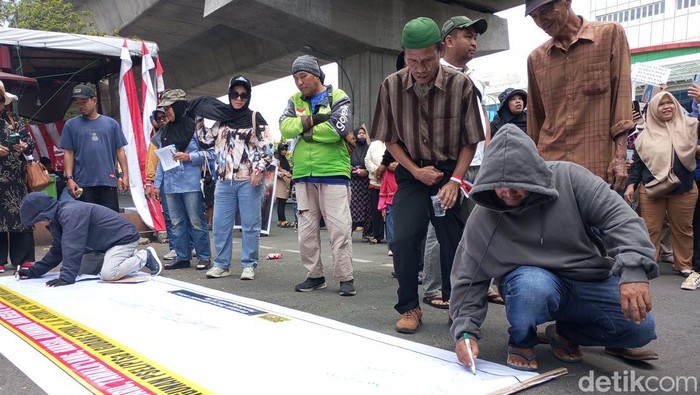Warga tanda tangan petisi penolakan PLTSa saat unjuk rasa di DPRD Kota Makassar, Rabu (6/8/2025).