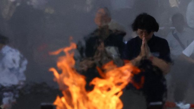People pray in front of the cenotaph for the victims of the 1945 atomic bombing, at the Peace Memorial Park in Hiroshima on the 80th Atomic Bombing Day anniversary in Hiroshima, western Japan, August 6, 2025. REUTERS/Kim Kyung-Hoon