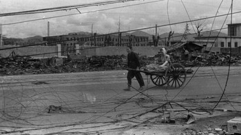 Seorang perempuan muda yang selamat dari ledakan di Minami-Ohashi, satu mil di selatan Ground Zero, ditarik oleh bibinya dengan kereta dorong melewati jalan yang tertutup puing-puing menuju Rumah Sakit Palang Merah Hiroshima pada 4 Oktober. | Foto: PetaPixel