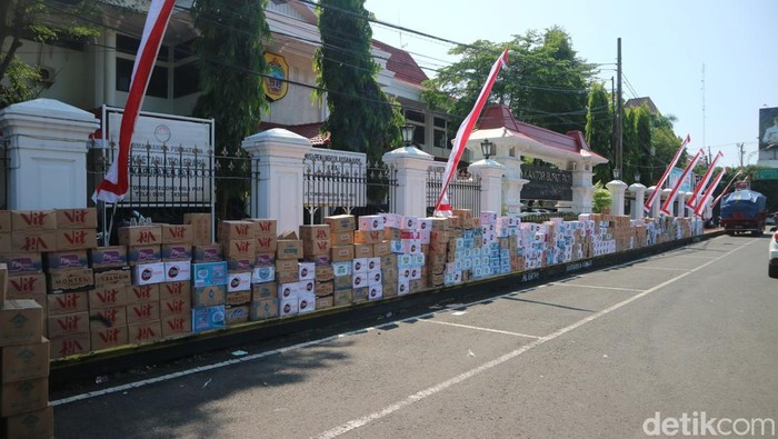 Dus-dus air mineral kemasan donasi untuk massa penolak kenaikan PBB di Pati dijejer di depan Kantor Bupati Pati, Kamis (7/8/2025).