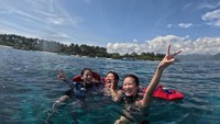 Potretnya bersama teman-temannya swmbari mengapung di lautan biru yang cantik