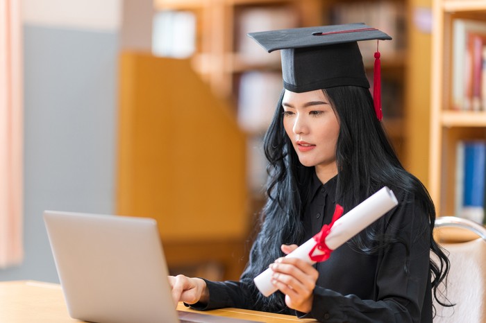 student is celebrating her graduation in a term  of social distancing by video conference on laptop computer.