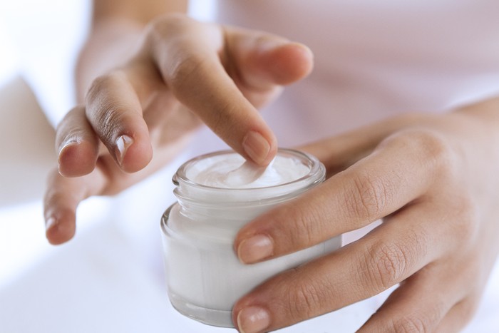 womans hand touching on the cream for applying